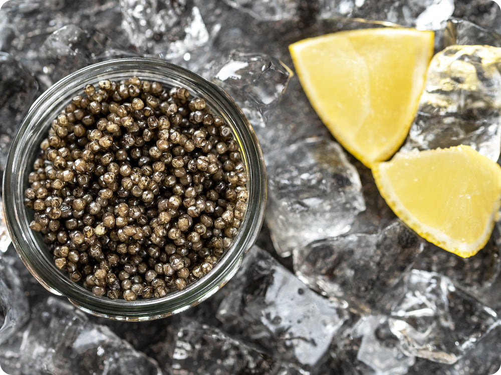 Osetra Caviar in a jar on ice with lemons